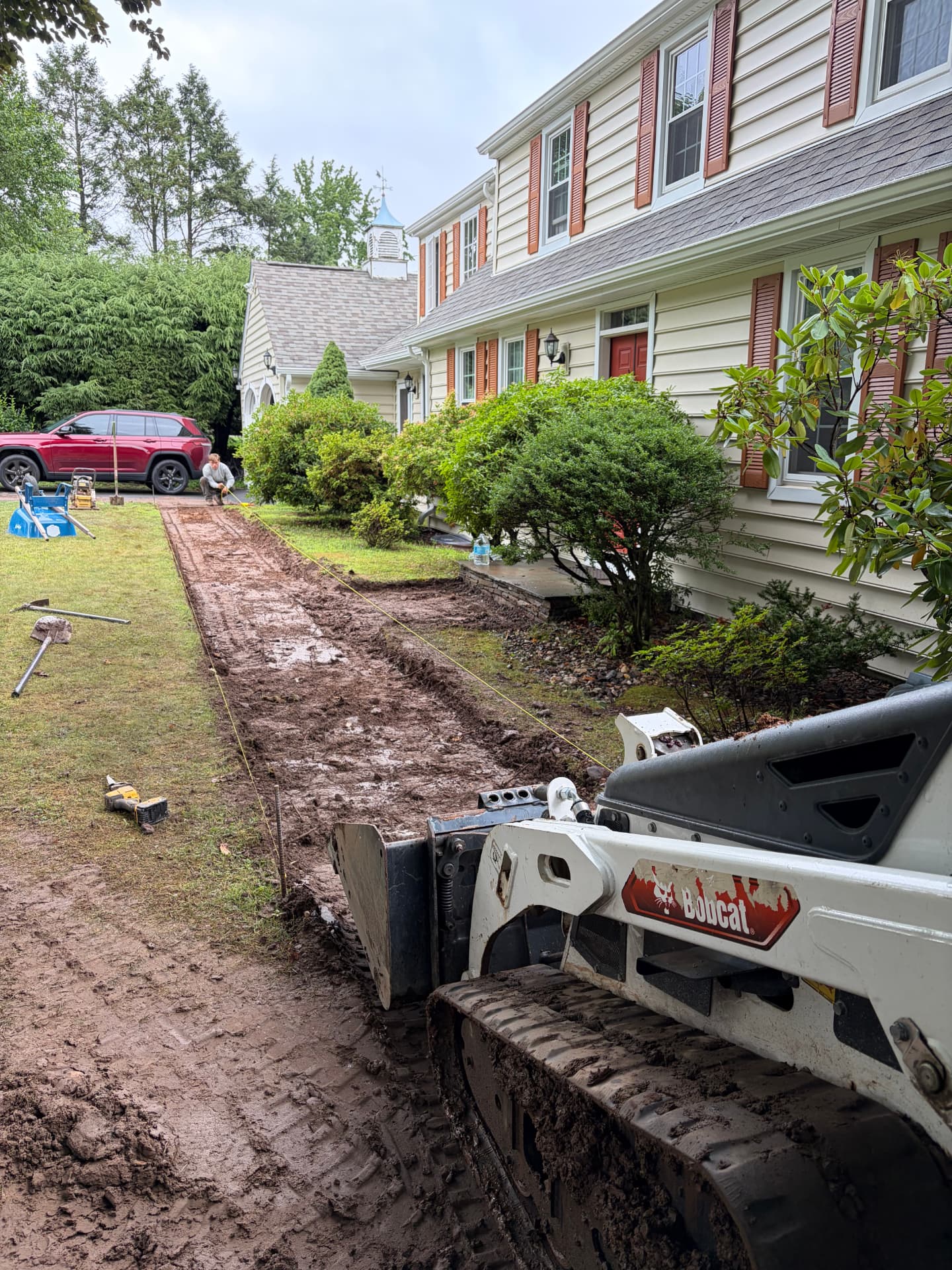Track loader excavating a walkway base