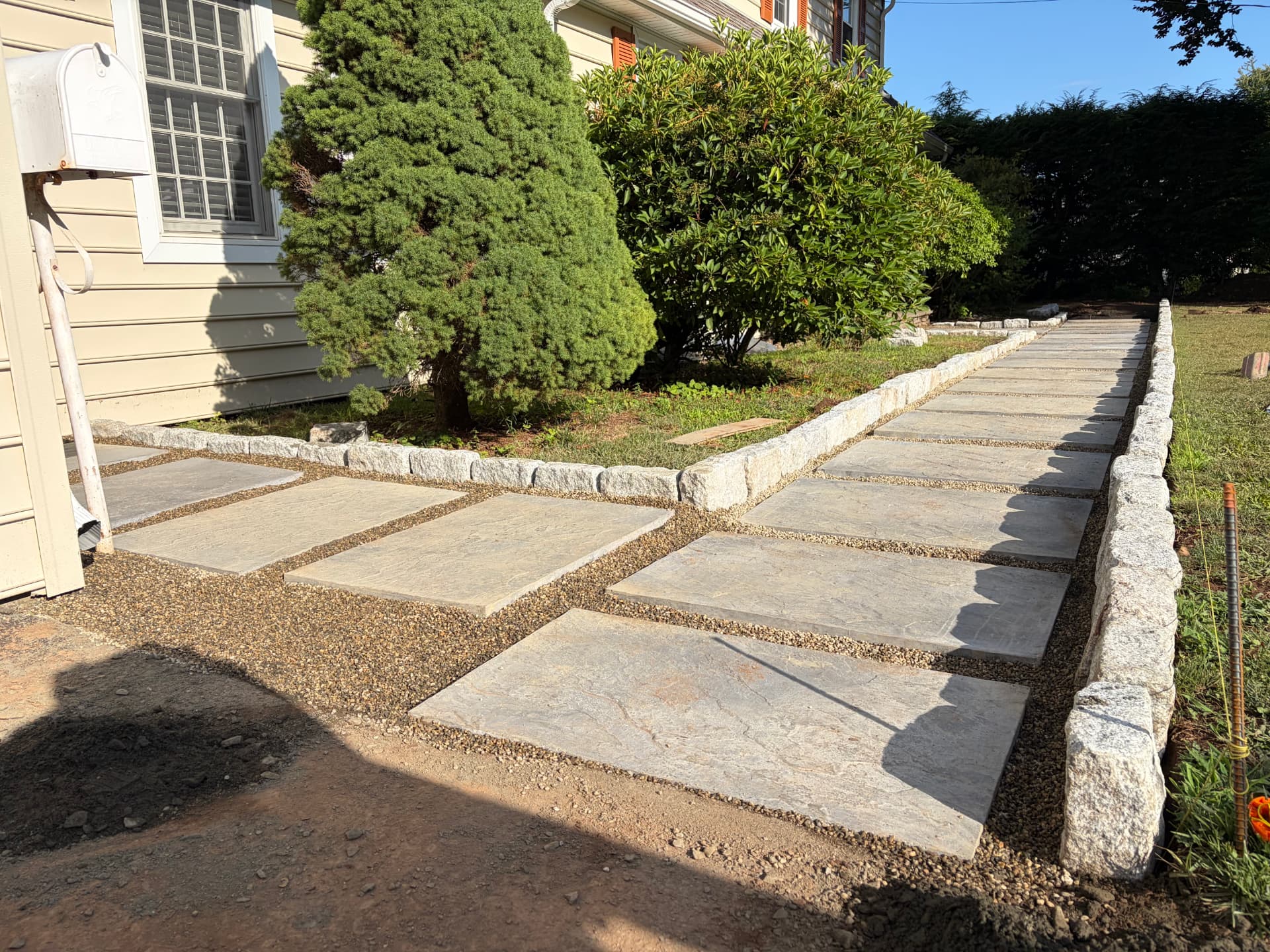 Bluestone walkway with granite cobble border in golden light