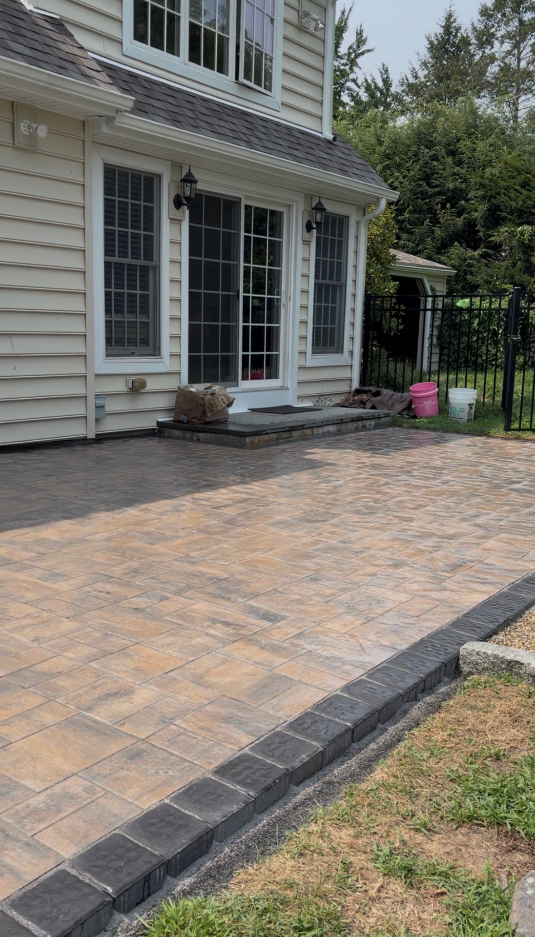 Newly finished paver patio with charcoal border course