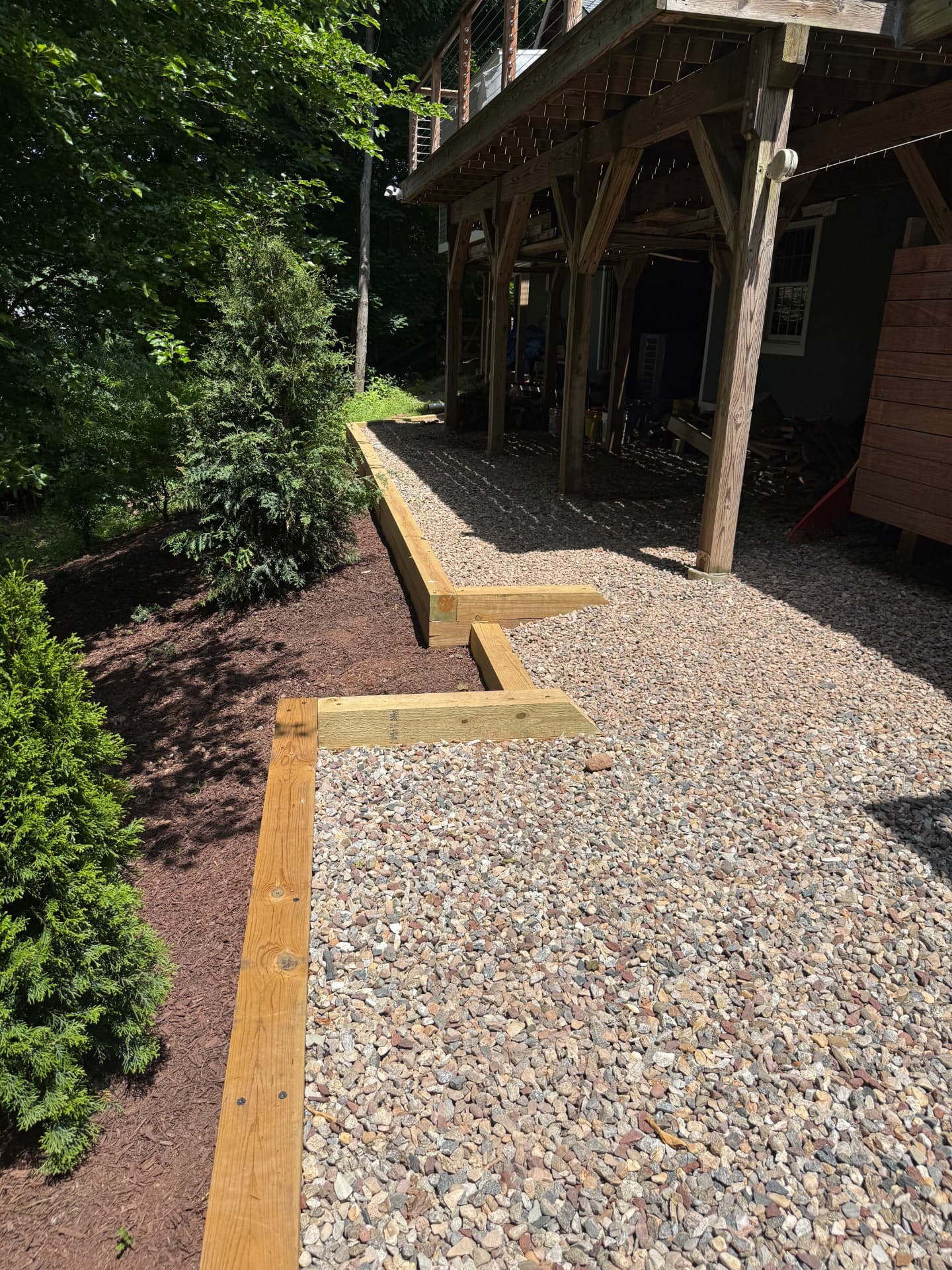 Timber-edged gravel path with fresh mulch beds